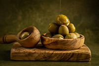 Drizzling golden olive oil over fresh harvest.